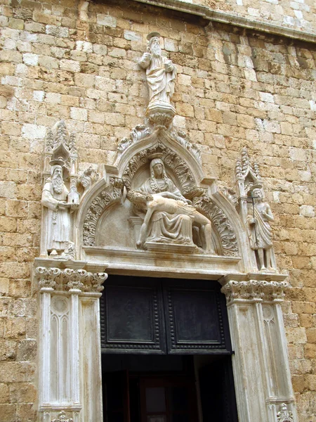 Pieta, zdobeným portálem františkánský klášter, staré město o — Stock fotografie