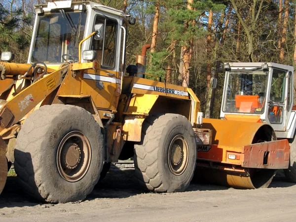 Bulldozer, road roller, earthmoving machinery and road construct — Stock Photo, Image