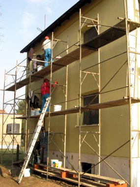 Application of colored plaster on the facade of the building clipart