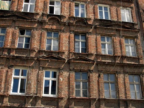 Wand mit Fenstern eines alten, beschädigten Wohnhauses in wro — Stockfoto