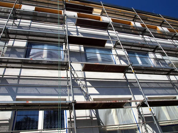 Detalle de la fachada de un gran edificio en las paredes aislantes con andamios visibles — Foto de Stock