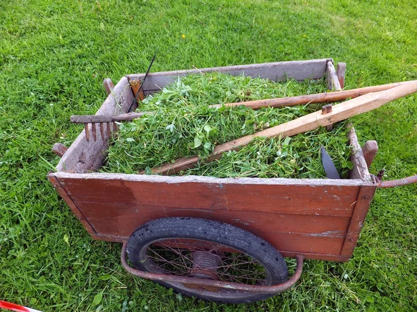 Alter LKW mit gemähtem Gras mit Sense, Harke und Schleifstein — Stockfoto