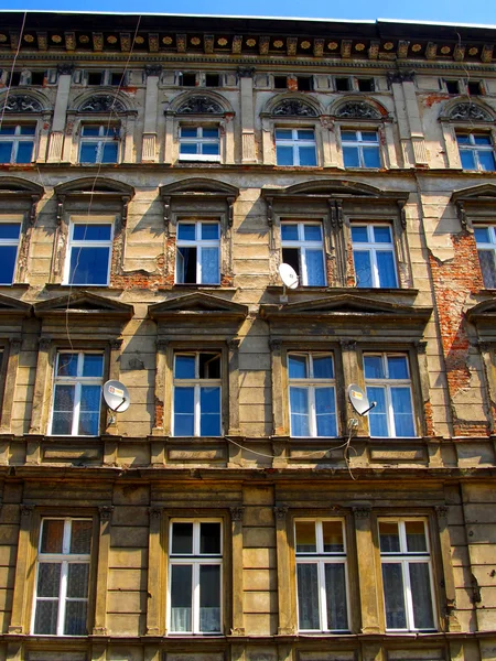 Wand mit Fenstern eines alten, beschädigten Wohnhauses in wro — Stockfoto