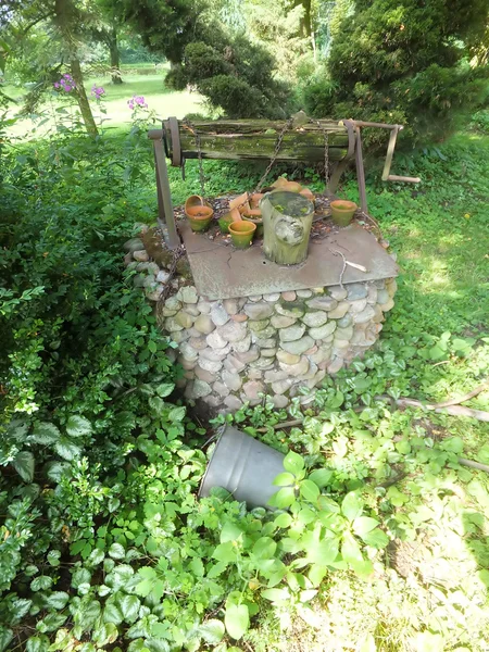 Muy viejo bien construido de piedras cubiertas de malas hierbas , —  Fotos de Stock