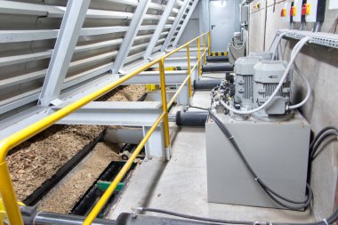 Hidrolik silindirler biyokütle kazıyıcı besleyiciyi çöp kutusundan kazıyıcıya iter.