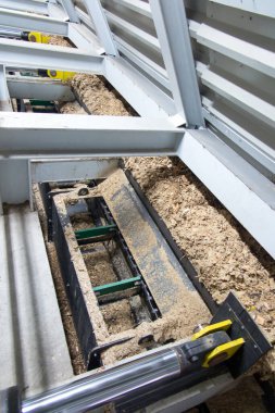 Hidrolik silindirler biyokütle kazıyıcı besleyiciyi çöp kutusundan kazıyıcıya iter.