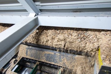 Hidrolik silindirler biyokütle kazıyıcı besleyiciyi çöp kutusundan kazıyıcıya iter.