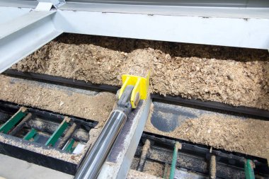 Hidrolik silindirler biyokütle kazıyıcı besleyiciyi çöp kutusundan kazıyıcıya iter.