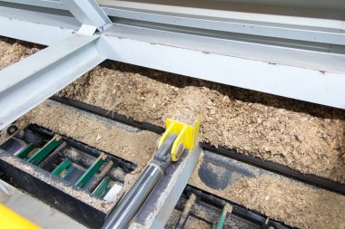 Hidrolik silindirler biyokütle kazıyıcı besleyiciyi çöp kutusundan kazıyıcıya iter.