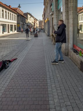 Tarnowskie Gory, Polonya, 22 Mart 2022: Bir müzisyen, sabah saatlerinde Tarnowskie Gory 'de boş bir Krakowska caddesinde (gezinti güvertesi) saksafon çalan bir adam.