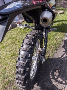 Bir enguro motorsiklet tekerleği (off-road ve on-road) ile yakın plan bir lastik ve karakteristik bir koruyucu.