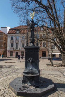 Varşova, Polonya, 24 Nisan 2022: Varşova 'da Yeni Şehir Meydanı ve üzerinde Yeni Şehir arması olan eski bir demir kuyusu..