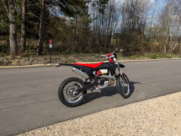 Güneşli bir havada asfalt bir yolda kırmızı bir off-road motosikleti..