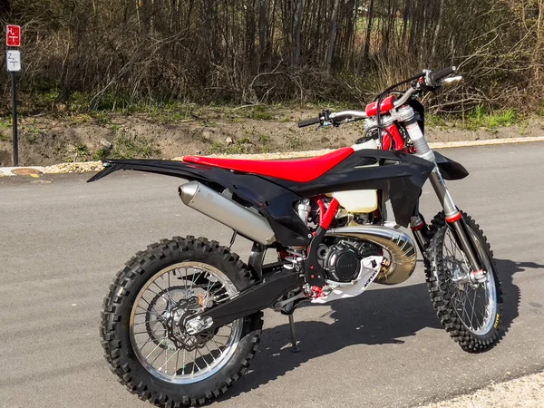 Güneşli bir havada asfalt bir yolda kırmızı bir off-road motosikleti..