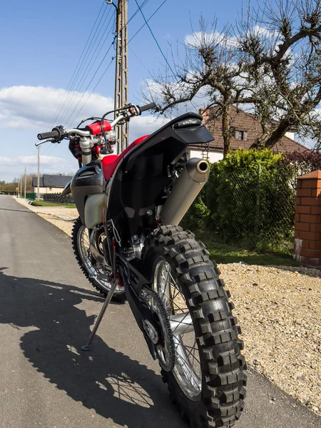 Güneşli bir havada asfalt bir yolda kırmızı bir off-road motosikleti..