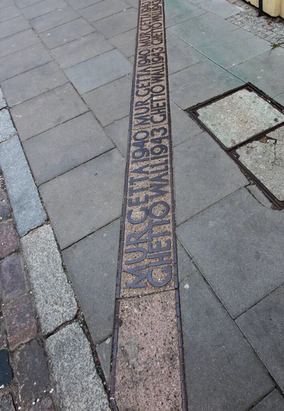 The place marked on the pavement where the wall of the Warsaw Ghetto was. Warsaw Poland.