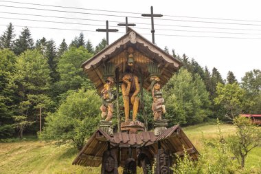 Zabnica, Poland, July 27, 2022: Wayside shrines and saints and various sculptures in the village of Zabnica in the Beskid Zywiecki mountains in Poland.