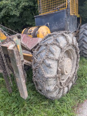 Chain on the wheels of a skidder, i.e. a tractor for skidding wood in difficult mountain terrain and with earthen ground.