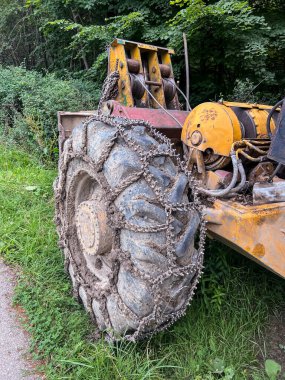 Chain on the wheels of a skidder, i.e. a tractor for skidding wood in difficult mountain terrain and with earthen ground.