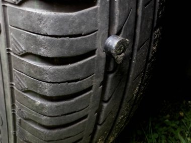 A metal screw hammered into a car tire.