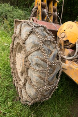 Chain on the wheels of a skidder, i.e. a tractor for skidding wood in difficult mountain terrain and with earthen ground.