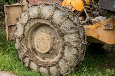 Chain on the wheels of a skidder, i.e. a tractor for skidding wood in difficult mountain terrain and with earthen ground.