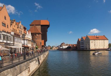 Gdansk, Polonya, 15 Mayıs 2022: Karakteristik ortaçağ Turnası ve limandaki Motlawa nehri yakınlarındaki tarihi binalarla nehir kenarı manzarası. Gdansk, Polonya.