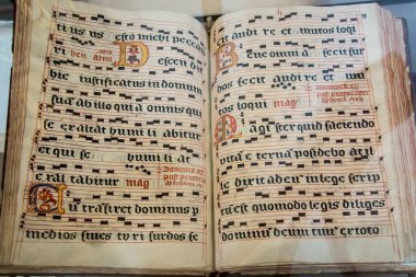 Zarnowiec, Poland, May 13, 2022: Church of the Annunciation of the Lord and the Benedictine Abbey in Zarnowiec in the Diocese of Gdansk. Fragment of old liturgical books, decorated, with musical notation. clipart