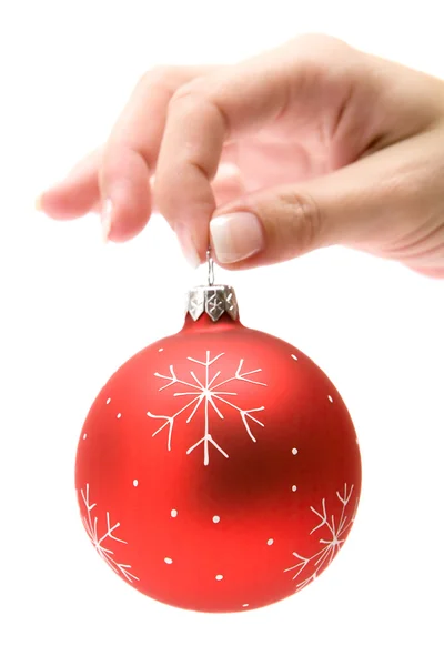 Segurando uma bola de árvore de Natal vermelho — Fotografia de Stock