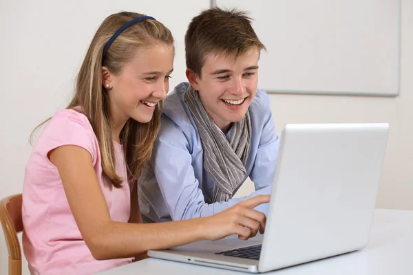 Twee jonge studenten die werken op een laptop — Stockfoto