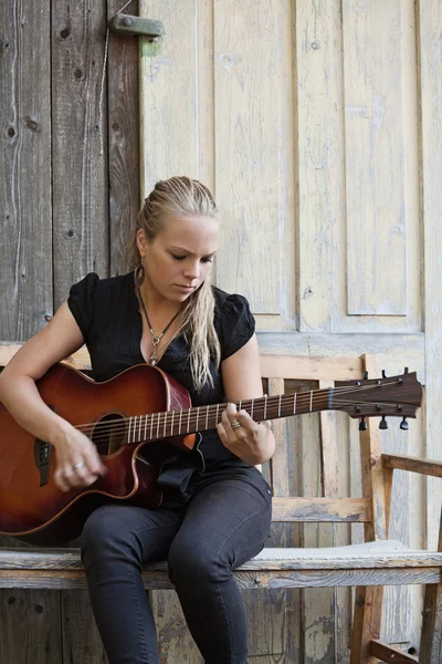 Spelar en akustisk gitarr — Stockfoto