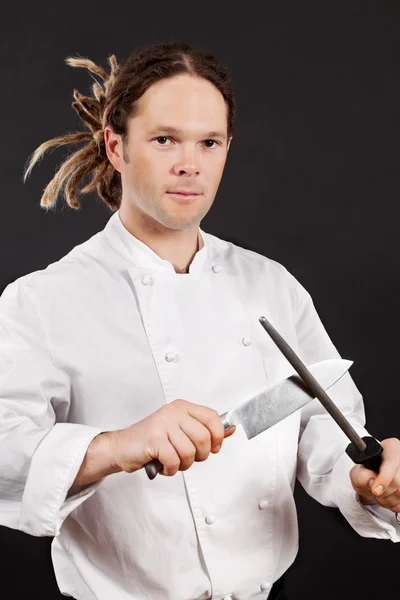 Handsome chef sharpening his knife — Stock Photo, Image