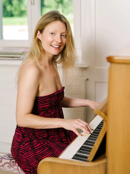 Belle blonde jouant du piano à la maison — Photo