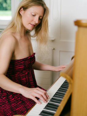 Adult female playing the piano clipart