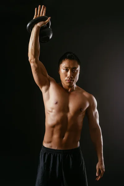 Asian man working out with kettle bell — Stock Photo, Image