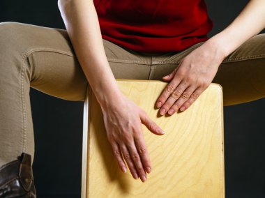 Closeup of a woman playing the Cajon clipart