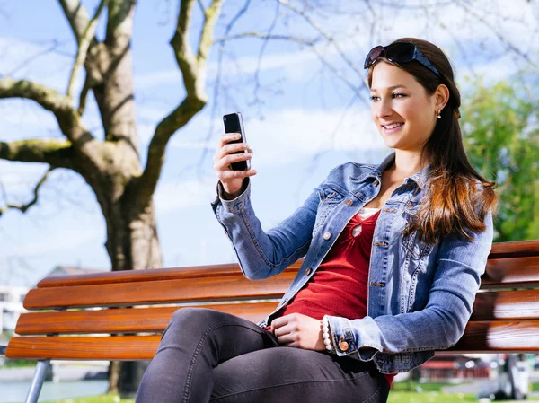 Texting with her smartphone — Stock Photo, Image