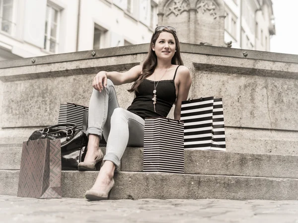 Jonge vrouw in de stad met shopping tassen — Stockfoto