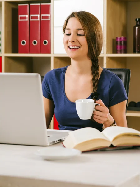 Student laughing in front of laptop — Stock Photo, Image