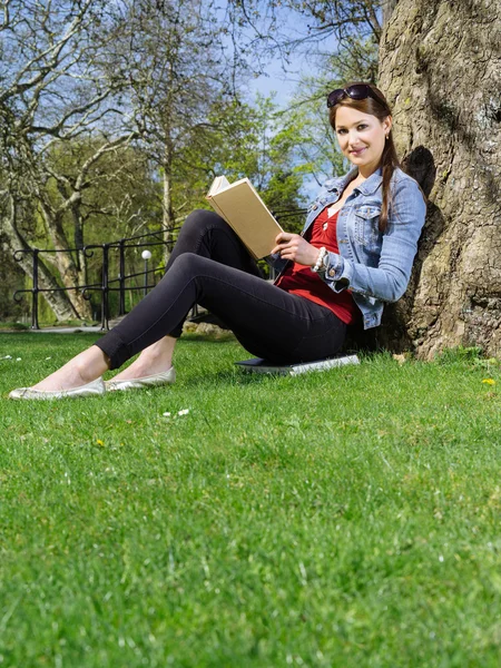 Νεαρή γυναίκα ανάγνωση στο πάρκο — Φωτογραφία Αρχείου