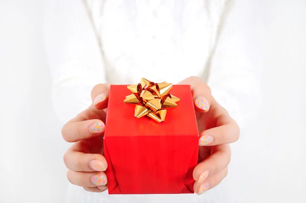 Ragazza mani con regalo rosso — Foto Stock
