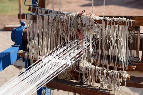 Vintage wooden loom with half knit colored carpet on threads — Stock Photo, Image