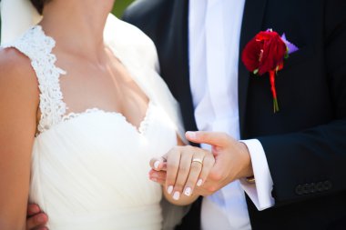 Gelin ve damat el ele tutuşuyorlar.