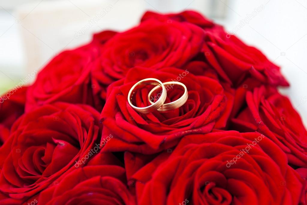 Wedding rings on red roses wedding bouquet