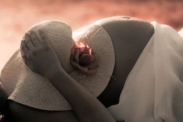 Mulher grávida segurando um chapéu — Fotografia de Stock