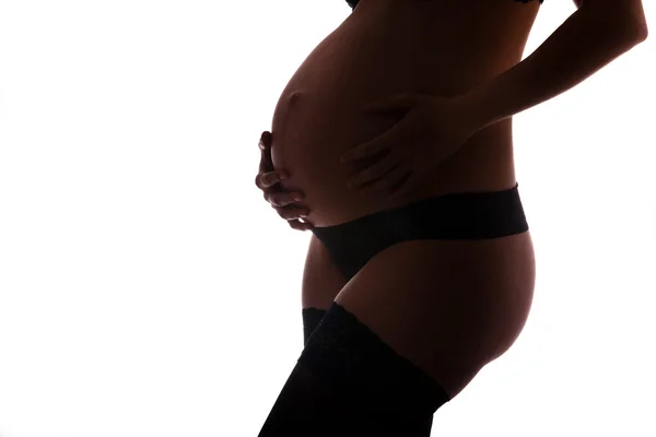 Mujer embarazada vistiendo lencería sosteniendo su vientre —  Fotos de Stock