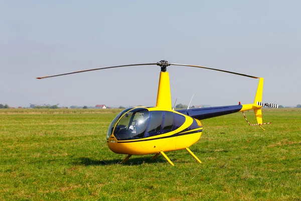 Yellow helicopter on field — Stock Photo, Image