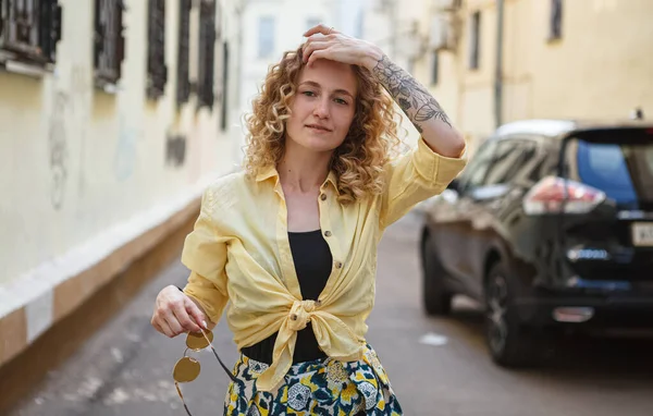 Şehirde poz veren dövmeli güzel bir kadın.