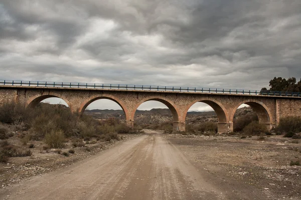 Stone bridge and dirt road — Stock Photo, Image