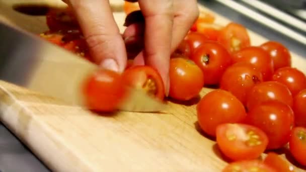 Tomates cereja sendo fatiados em uma tábua de corte . — Vídeo de Stock